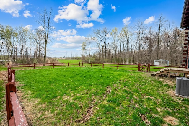 view of yard with fence, a rural view, and cooling unit