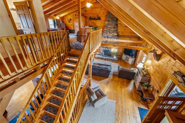 living area featuring hardwood / wood-style floors, vaulted ceiling with beams, and wooden walls