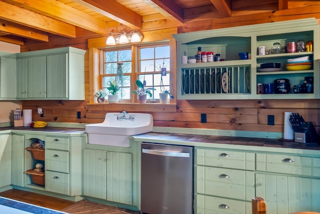 kitchen featuring tile counters, wooden walls, stainless steel dishwasher, and beamed ceiling