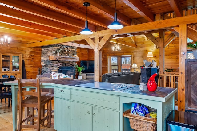 kitchen featuring beamed ceiling, wood walls, a notable chandelier, and electric cooktop