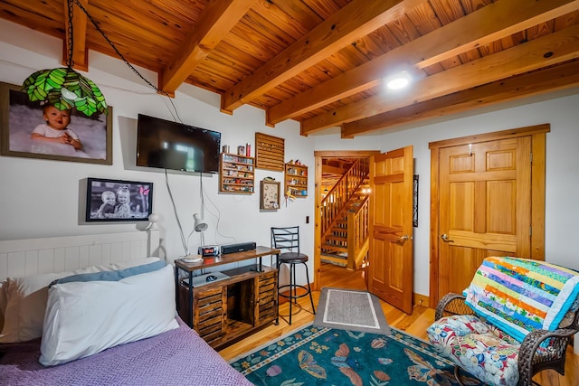 bedroom with wood ceiling, wood finished floors, and beamed ceiling
