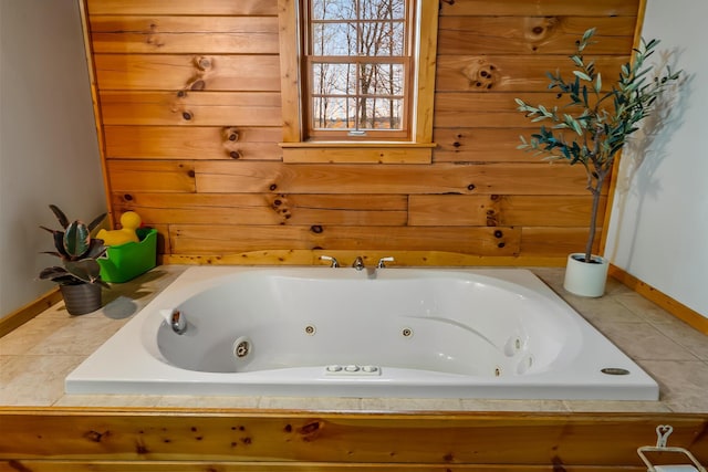 full bath featuring a jetted tub and baseboards