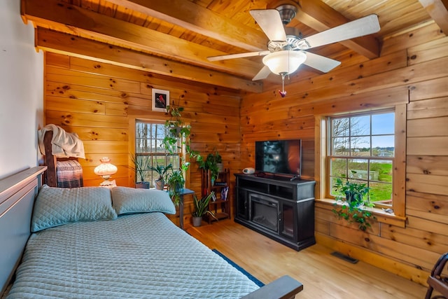 bedroom with beam ceiling, multiple windows, and visible vents