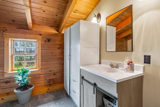 bathroom with beamed ceiling, wooden walls, vanity, and wood ceiling