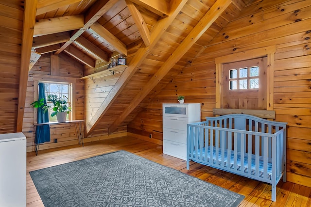 unfurnished bedroom featuring lofted ceiling with beams, wood-type flooring, wooden ceiling, and multiple windows