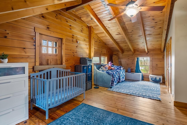 bedroom with wooden ceiling, wood walls, wood-type flooring, and vaulted ceiling with beams