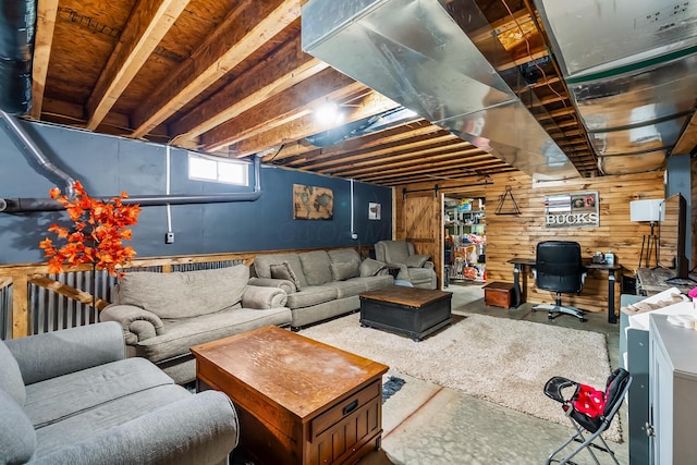 living room featuring concrete flooring and wood walls