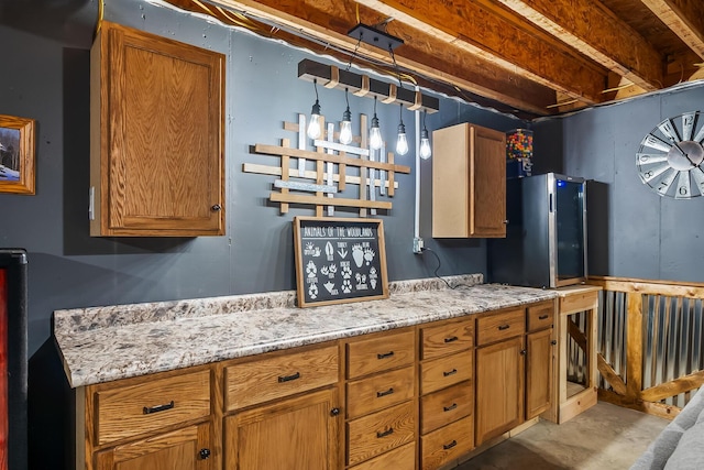 kitchen with brown cabinets, concrete flooring, and light stone countertops