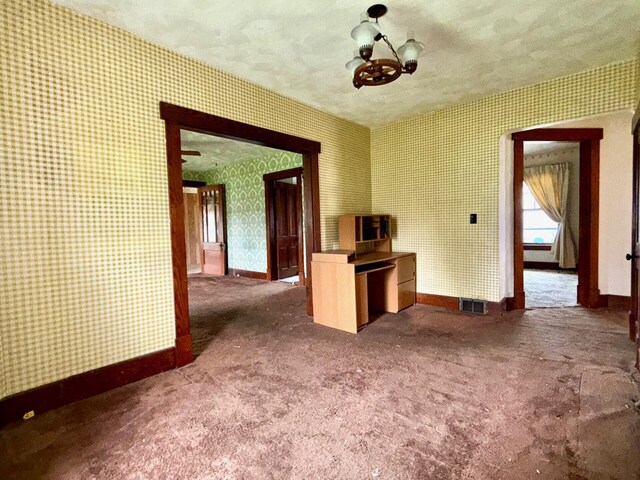 15825 State Route 207, Mount Sterling, OH 43143 - unfurnished room with wallpapered walls, dark carpet, and a chandelier
