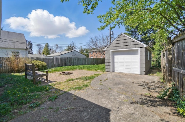 detached garage with driveway and fence