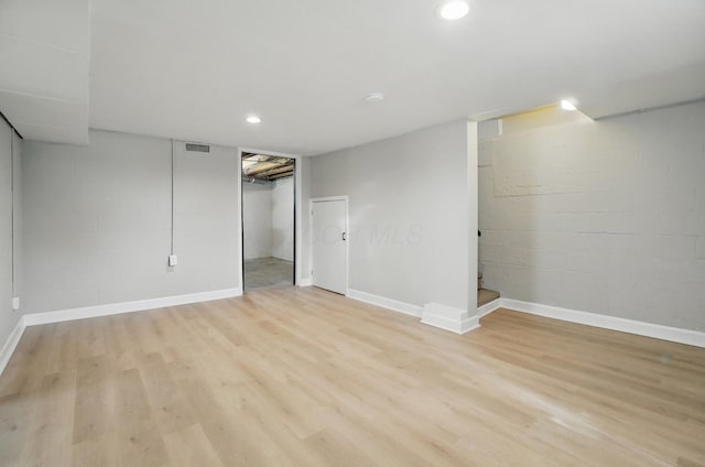 finished basement featuring recessed lighting, light wood finished floors, concrete block wall, visible vents, and baseboards