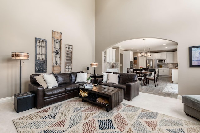 6509 Spring Run Dr, Westerville, OH 43082 - living room with arched walkways, baseboards, an inviting chandelier, a high ceiling, and light carpet