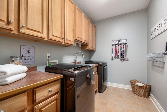 6509 Spring Run Dr, Westerville, OH 43082 - clothes washing area featuring cabinet space, light tile patterned flooring, baseboards, and washing machine and clothes dryer