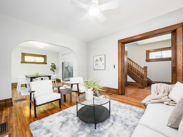 384 E 13th Ave, Columbus, OH 43201 - living room with arched walkways, stairs, light wood finished floors, and baseboards