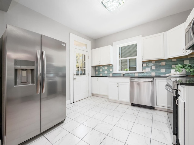 384 E 13th Ave, Columbus, OH 43201 - kitchen featuring white cabinets, stainless steel appliances, a sink, dark countertops, and backsplash
