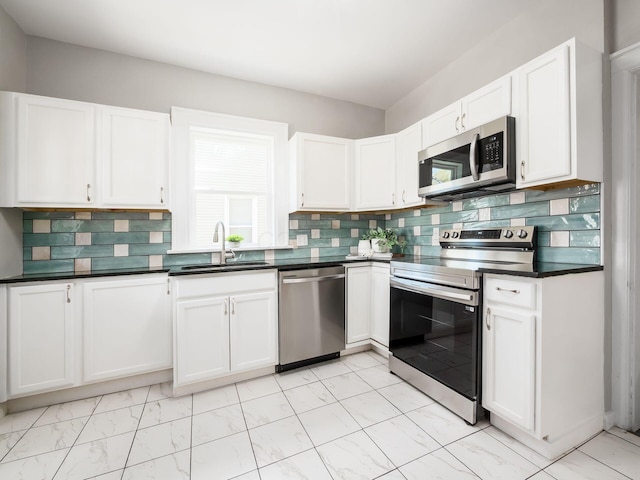 384 E 13th Ave, Columbus, OH 43201 - kitchen featuring dark countertops, a sink, marble finish floor, stainless steel appliances, and white cabinets