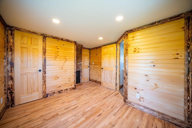 spare room featuring wood walls, recessed lighting, and light wood-style flooring