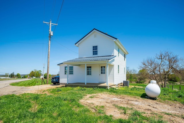 back of property with a porch, a yard, and cooling unit