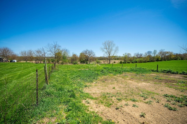view of yard featuring fence and a rural view
