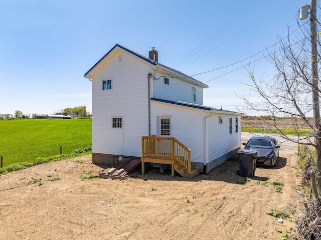 back of property featuring a lawn and a chimney