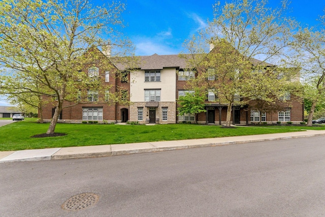view of front facade featuring brick siding and a front lawn