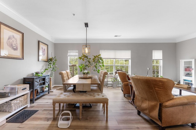 dining space featuring visible vents, crown molding, and wood finished floors
