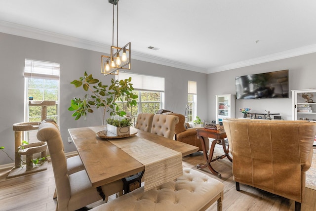 dining space featuring visible vents, crown molding, plenty of natural light, and light wood-type flooring