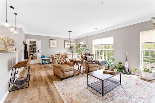 living room featuring light wood-style floors, a healthy amount of sunlight, and an inviting chandelier