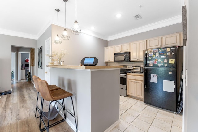 kitchen with visible vents, black appliances, light brown cabinets, ornamental molding, and a breakfast bar