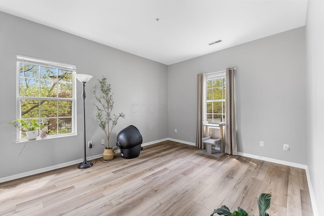 unfurnished room with baseboards, light wood-style flooring, and visible vents