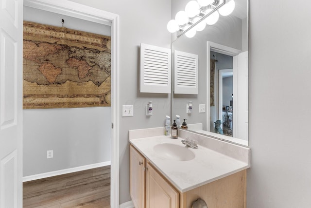 bathroom with vanity, baseboards, and wood finished floors