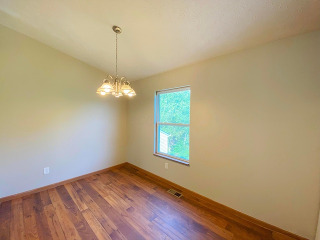 829 Crevis Ln, Columbus, OH 43228 - unfurnished room featuring wood finished floors and a chandelier