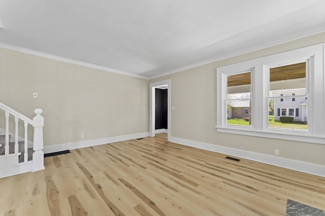unfurnished living room featuring stairway, visible vents, light wood-style floors, crown molding, and baseboards