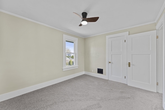 unfurnished bedroom with crown molding, ceiling fan, carpet, baseboards, and visible vents
