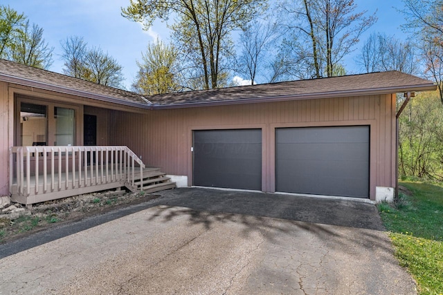 garage with driveway and a porch