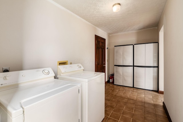 laundry area with tile patterned floors, washer and dryer, laundry area, and a textured ceiling