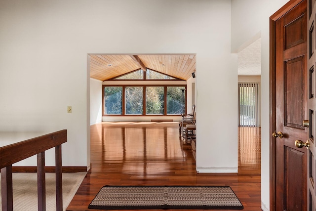 interior space featuring baseboards, wooden ceiling, wood finished floors, and lofted ceiling with beams