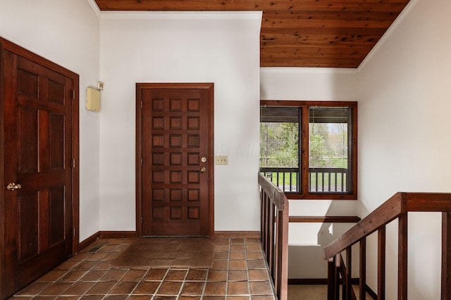 entryway featuring baseboards, ornamental molding, and wood ceiling