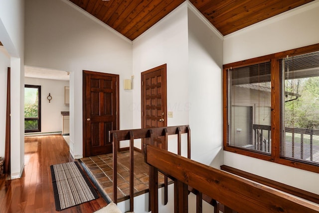 hallway featuring ornamental molding, a wealth of natural light, wood finished floors, and wood ceiling