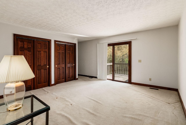 interior space with baseboards, visible vents, carpet floors, and a textured ceiling