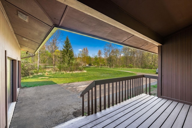 wooden deck featuring a patio area and a lawn