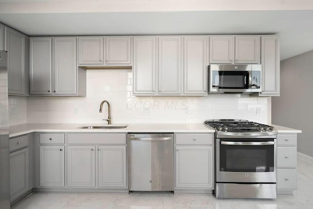 50 W Broad St Unit 2104, Columbus, OH 43215 - kitchen featuring marble finish floor, stainless steel appliances, gray cabinets, a sink, and tasteful backsplash