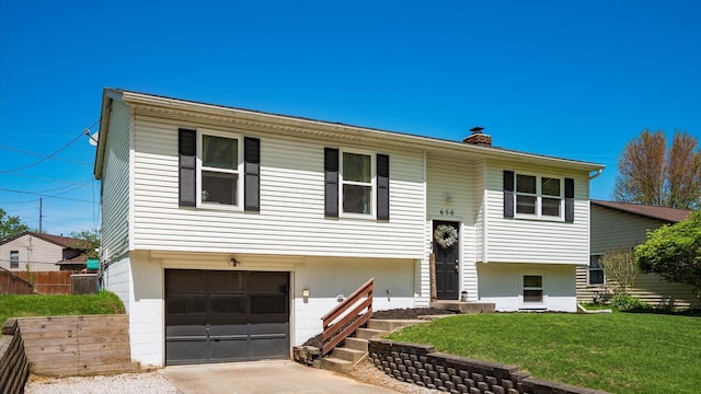 650 Licking View Dr, Heath, OH 43056 - bi-level home with a chimney, an attached garage, a front lawn, central AC unit, and driveway