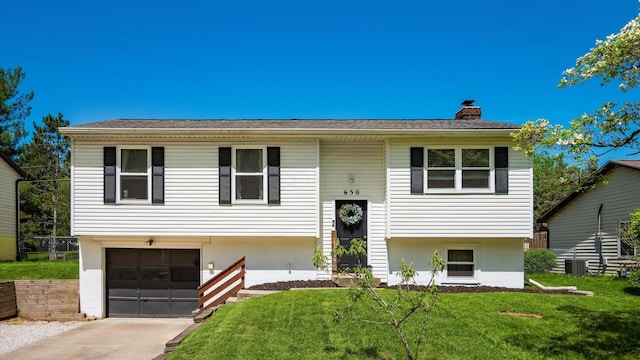 650 Licking View Dr, Heath, OH 43056 - raised ranch featuring an attached garage, a front yard, a chimney, concrete driveway, and central AC
