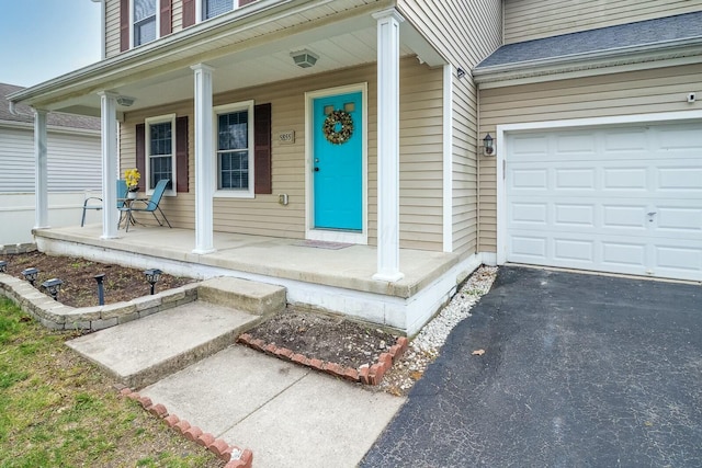doorway to property with a porch and a garage