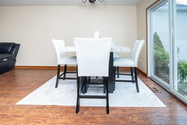 dining area featuring baseboards, wood finished floors, and visible vents