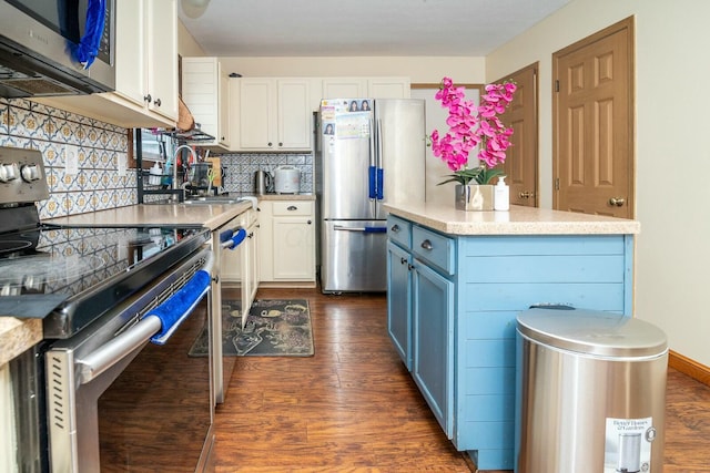kitchen featuring blue cabinetry, dark wood finished floors, appliances with stainless steel finishes, and white cabinetry