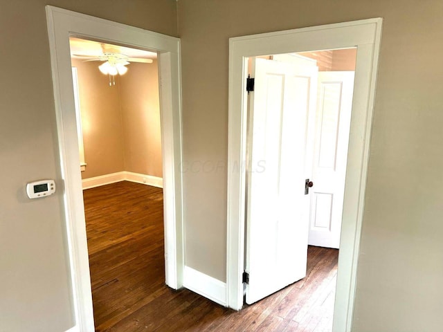hall with wood-type flooring and baseboards