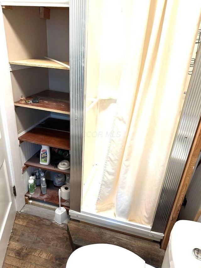 full bath featuring wood finished floors, toilet, and a shower with curtain