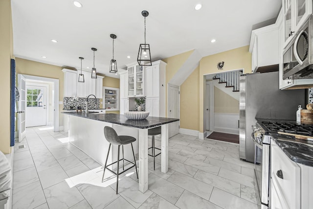 1812 Newark Granville Rd, Granville, OH 43023 - kitchen with appliances with stainless steel finishes, light marble finish flooring, baseboards, a kitchen breakfast bar, and recessed lighting